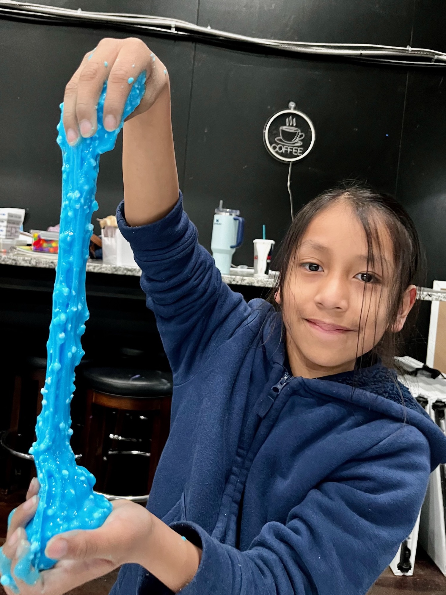 A girl stretching a long string of blue slime