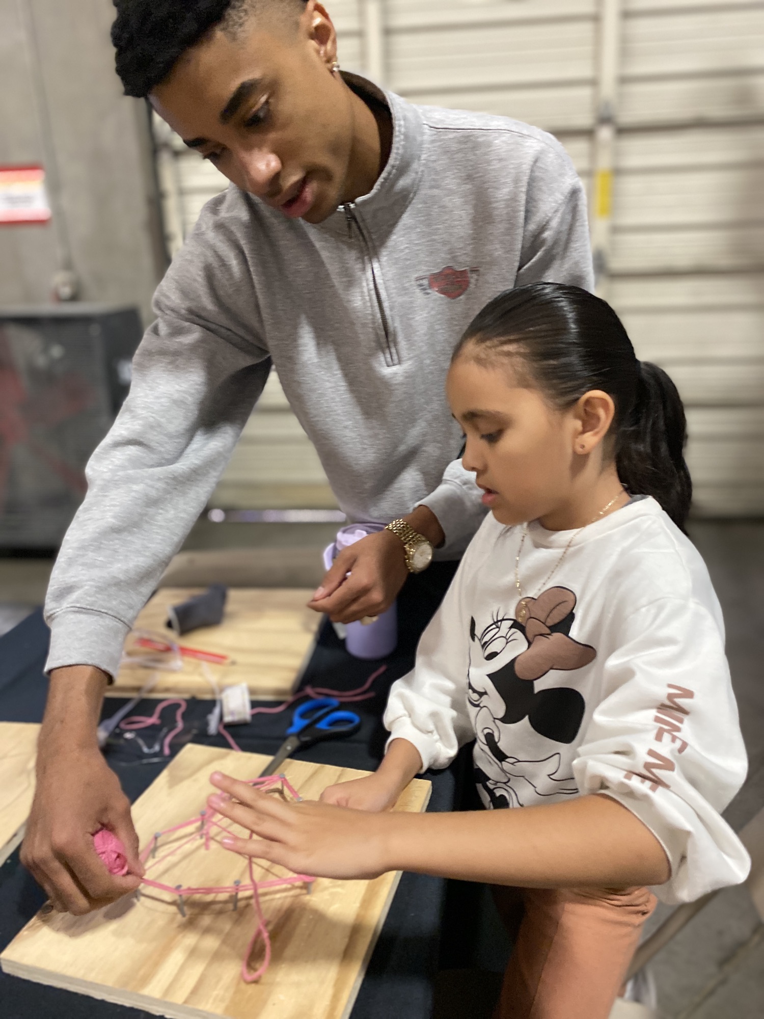 A mentor helping a girl with a craft project